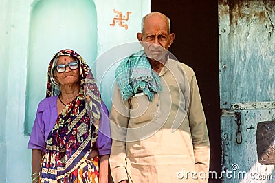 An elderly Hindu couple standing outside their rural home, Rajasthan, Northern India Editorial Stock Photo