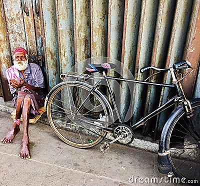 Elderly hindu cyclist resting on the street with his bicycle Editorial Stock Photo