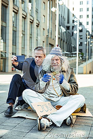 Elderly homeless hippy feeling astonished after help Stock Photo