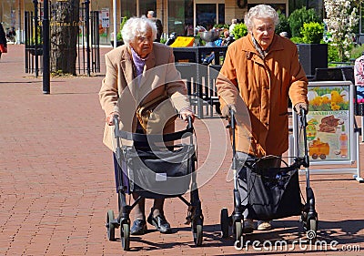 Old ladies wheeled walkers rollator, outdoor street Netherlands Editorial Stock Photo