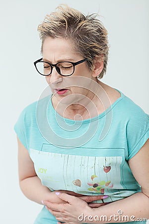 Elderly lady in excruciating stomachache Stock Photo