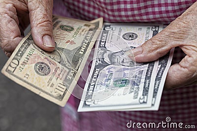 An elderly lady holds 20 dollars Stock Photo