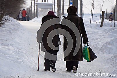 Elderly lady with a walking stick talking to a female on a seaside promenade. Stock Photo