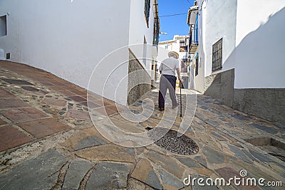 Elderly local man climbing slope narrow street of Comares, Malaga, Spain Stock Photo