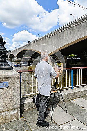 Elderly male artist painting on canvas with oil paint. Outdoors leisure activities Editorial Stock Photo