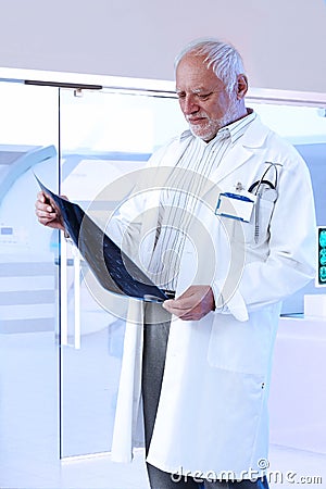 Elderly male doctor checking scan at hospital Stock Photo