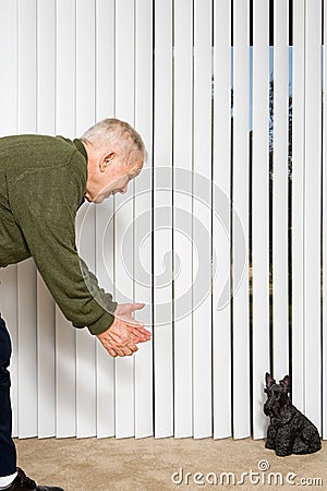 Elderly man beckoning dog ornament Stock Photo