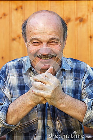 Elderly man claps his hands with delight Stock Photo