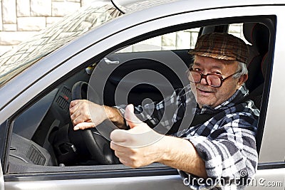 Elderly man driving the car and shows the thumb Stock Photo