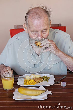 Elderly man eating healthy lunch in care home Stock Photo