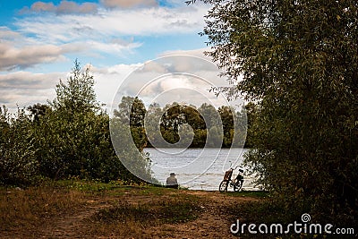 Elderly man enjoying a leisurely fishing activity in Gomel, Belarus on a picturesque autumn day Editorial Stock Photo