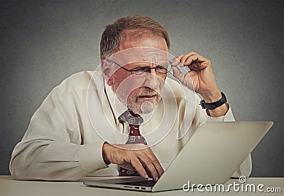 Elderly man with glasses confused with laptop software Stock Photo