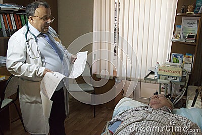 Health care, elderly and medical concept - cardiologist doctor with an elderly patient performs an EKG Editorial Stock Photo