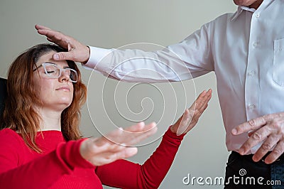 An elderly man hypnotizes a female patient. A woman in a session with a male hypnotherapist during a session. Therapist Stock Photo