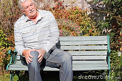 Elderly man in discomfort with a knee. Arthritis. Stock Photo