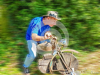 Elderly man playing a wooden motorcycle racer Stock Photo