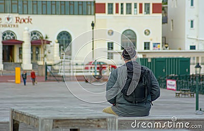 Elderly man sits alone outdoors. Editorial Stock Photo