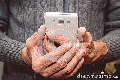 Elderly man standing with mobile phone in hand Stock Photo