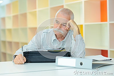 Elderly man with thoughful face indoors Stock Photo