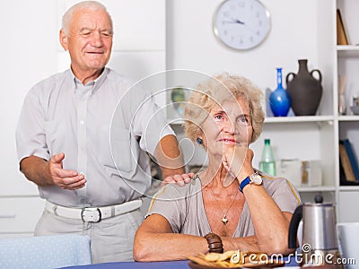 Elderly man trying to apologize to offended woman Stock Photo