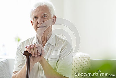 Elderly man with wooden walking stick in the nursing house Stock Photo