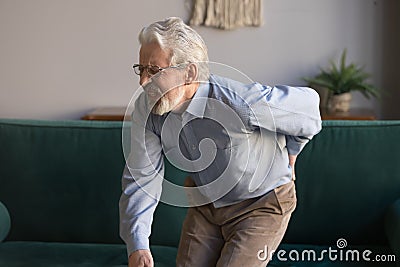 Elderly man writhes in pain suffers from low back strain Stock Photo