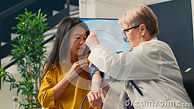 Elderly medic measuring hypertension and pulse pressure Stock Photo