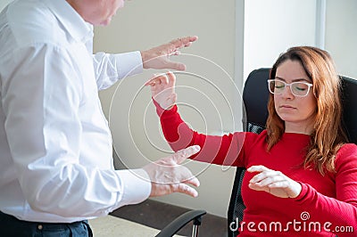 An elderly man hypnotizes a female patient. A woman in a session with a male hypnotherapist during a session. Therapist Stock Photo