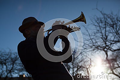 An elderly musician plays in the street on a trumpet Stock Photo