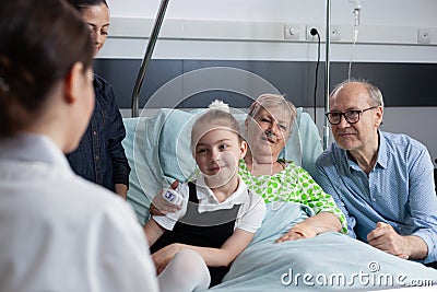 Surgeon visiting grandmother bedridden in sanatorium room Stock Photo