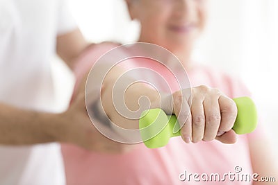 Elderly patient holding minor dumb-bell Stock Photo