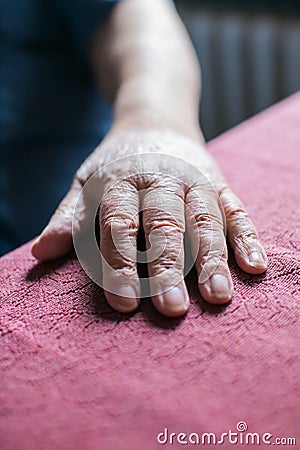 elderly person& x27;s hand resting on table Stock Photo