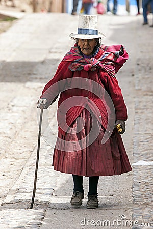 An elderly Peruvian woman walks down a street in the town of Maras in Peru. Editorial Stock Photo