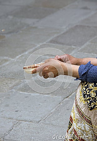 Elderly poor Gypsy woman begs for alms Stock Photo