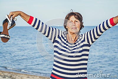 Elderly pretty woman enjoys relaxing by the sea Stock Photo