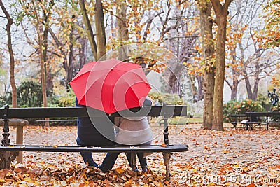 Elderly retired couple sitting together on the bench in autumn park, love concept Stock Photo