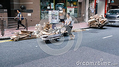 Elderly scavenger with cardboard on her trolley to earn a few dollars Editorial Stock Photo