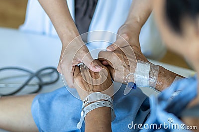Elderly senior aged patient on bed with geriatric doctor holding hands for trust and nursing health care, medical treatment Stock Photo