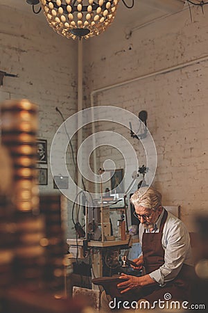 An elderly shoemaker in uniform indoors Stock Photo