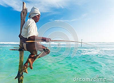 Elderly stilt fisherman at Hikkaduwa Beach. Editorial Stock Photo