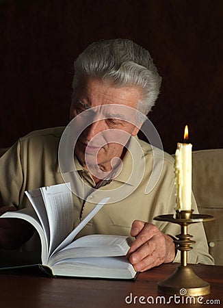 Elderly thoughtful man with book Stock Photo