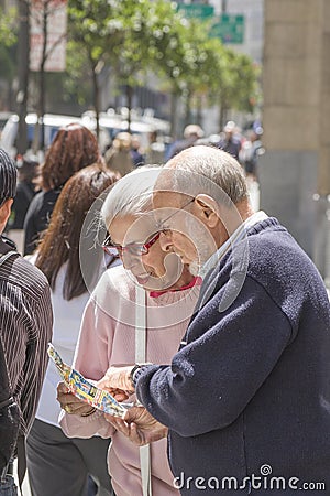 Elderly tourist couple studies the town map to find the way downtown San Francisco Editorial Stock Photo