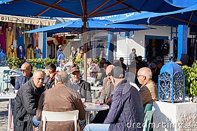 Elderly Tunisian men sit under umbrellas in the cafe and enjoy the morning with tea or coffee Editorial Stock Photo