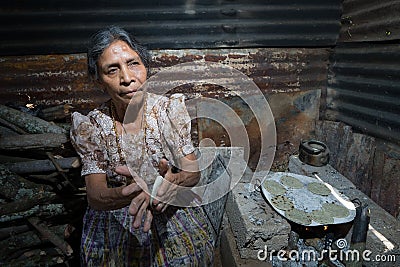 An elderly tzutujil mayan woman cooking Editorial Stock Photo