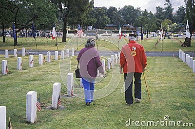 Elderly Veteran and Wife in Cemetery Editorial Stock Photo