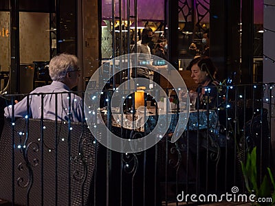 Elderly White Caucasian couple dining al-fresco at Joie vegetarian restaurant, Orchard Central, Orchard Road Singapore Editorial Stock Photo
