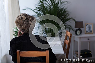 Elderly widow sitting alone Stock Photo