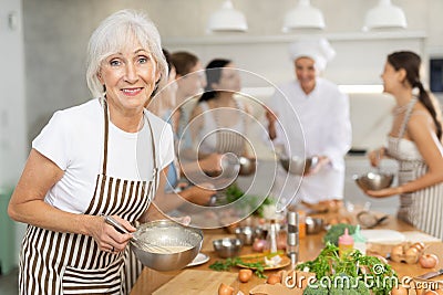 Elderly woman learns to cook at master class Stock Photo