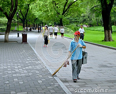 An elderly woman cleaners work for beihai park in Beijing Editorial Stock Photo