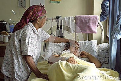 Elderly woman comforting sick sister in hospital Editorial Stock Photo
